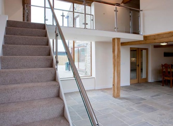 An open staircase leading to galleried landing overlooking the spacious living area below.